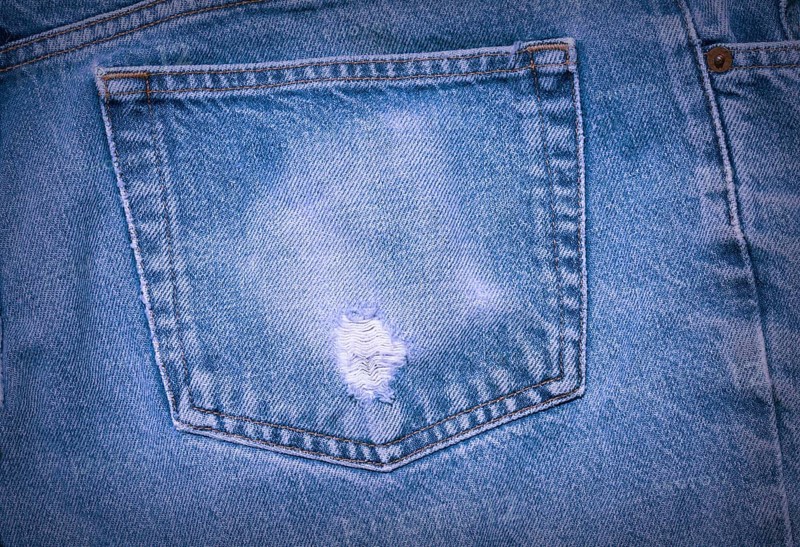 A Worn and tattered blue Jeans pocket