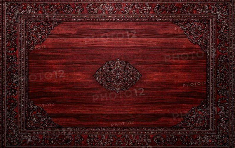 A wooden table with a red rug underneath it. The rug has a design on it. The table is empty AI generated