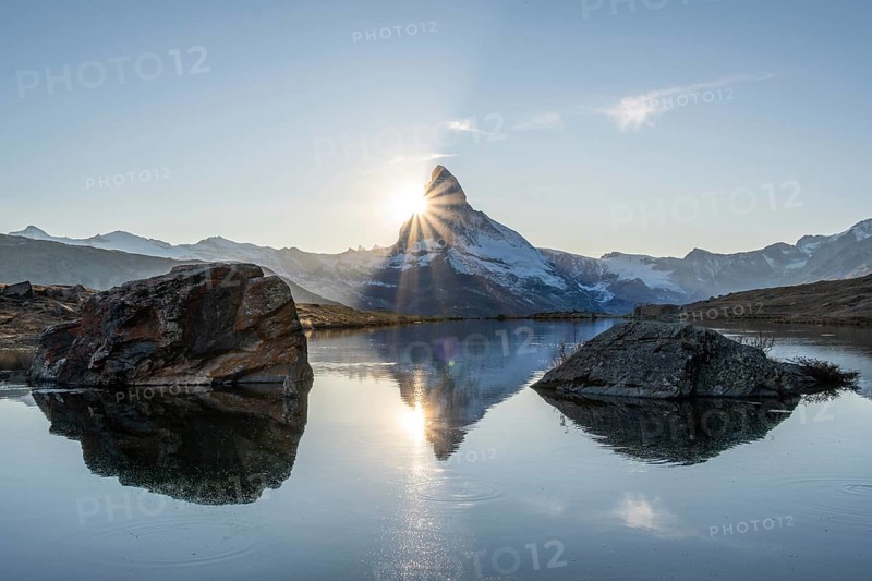 Matterhorn Mountain and Reflection in Lake Stellisee at Sunset. Sun is Setting behind the Mountain. Swiss Alps. Valais, Switzerland