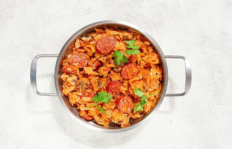 Polish dish bigos, in a stainless steel pan, stewed meat with cabbage, chorizo sausages, mushrooms, homemade, without people