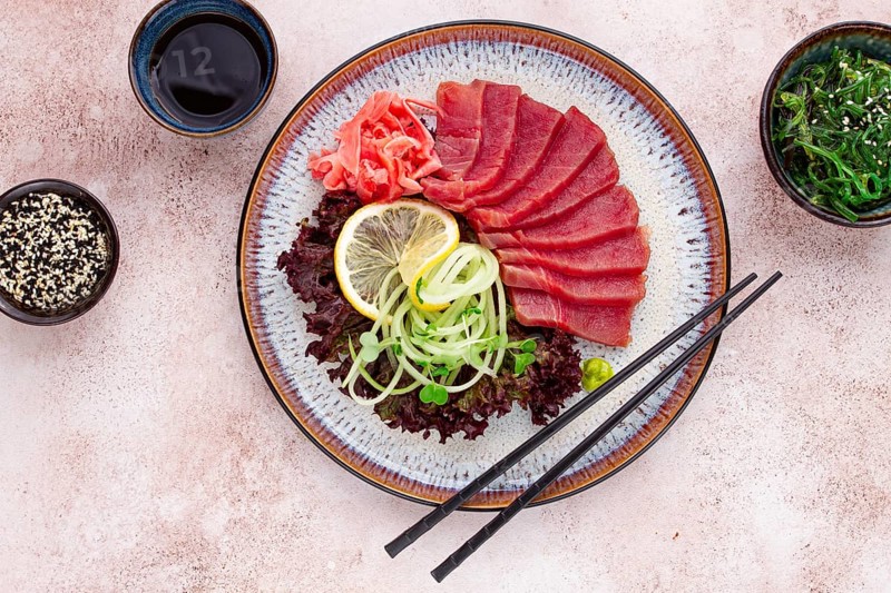 Freshly prepared sashimi with vibrant garnishes served on a decorative plate