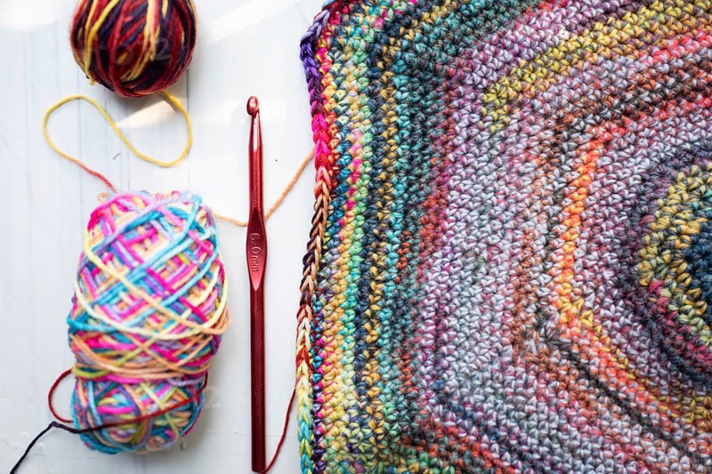 Crochet hooks, wool and crocheted blanket