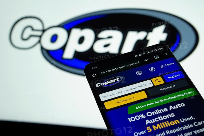 Dhaka, Bangladesh- 03 July 2025: Smartphone displaying Copart web interface against Copart logo background