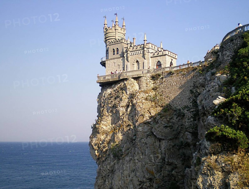 A stunning panorama of the Swallow's Nest castle, towering over the Black Sea. View from the staircase of the 40-meter-high Aurora Rock. The palace itself is a unique historical monument of Crimean architecture and cultural heritage, a well-known landmark for tourists and travelers. It was built between 1889 and 1912. Its owners were wealthy Russian nobles, some of the most influential people in the Russian Empire. Southern Coast of Crimea, Gaspra, Ukraine