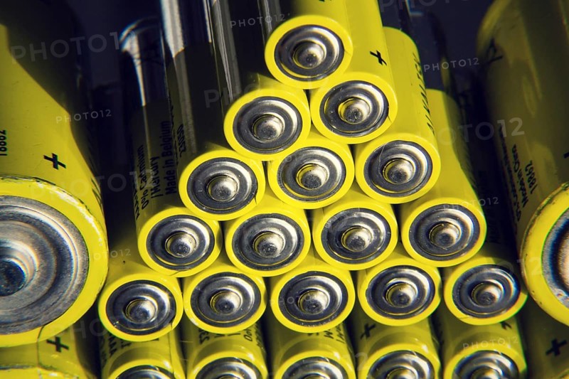 Yellow double A batteries reflecting in mirror, electricity storage concept