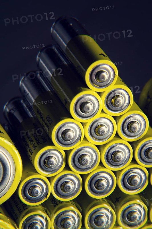 Yellow double A batteries reflecting in mirror, electricity storage concept