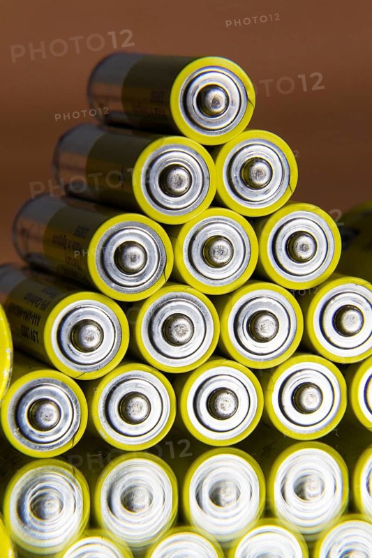 Stack of yellow AA batteries close up abstract coloured background