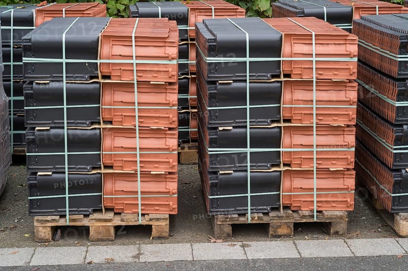 Borken, NRW, Germany, New terracotta and black roof tiles packaged on wooden pallets for construction