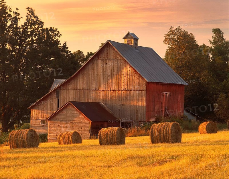 A barn in North Hero, Vermont with round bales of hay