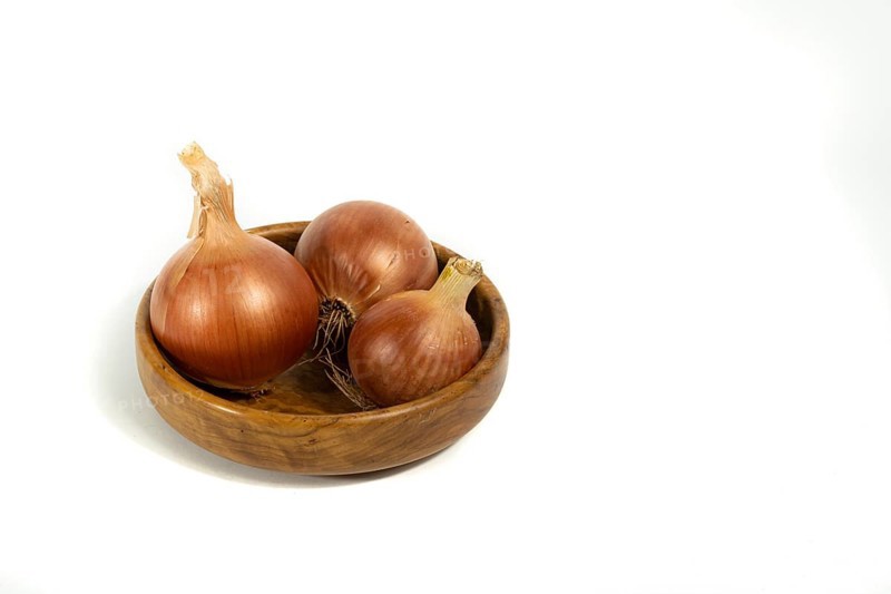 Organic onions seen from the front on a white background with copy-space