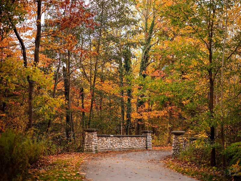 Pathway leading to a stone bridge with trees in autumn colors along the Thames Valley Parkway in London, Ontario, Canada
