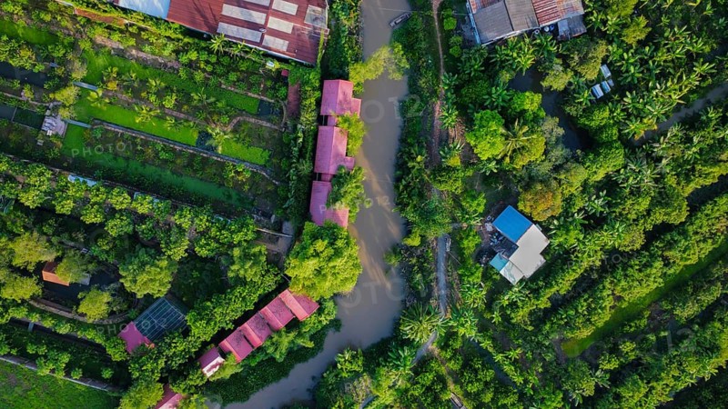 A small wooden boat in a river surrounded by nature, in Vietnam, Asia, seen from above