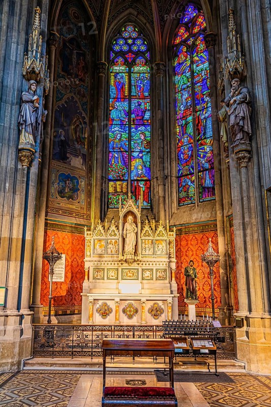The altar and colorful windows in the neo-gothic votive church, Vienna, Austria