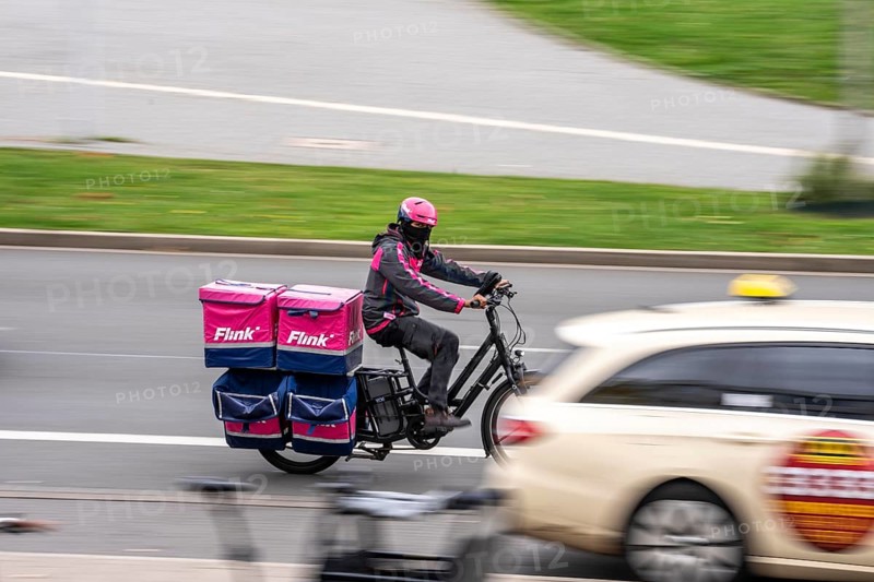 Quick delivery service bike, passes by taxis, at Düsseldorf-Bilk railway station, taxi stand, North Rhine-Westphalia