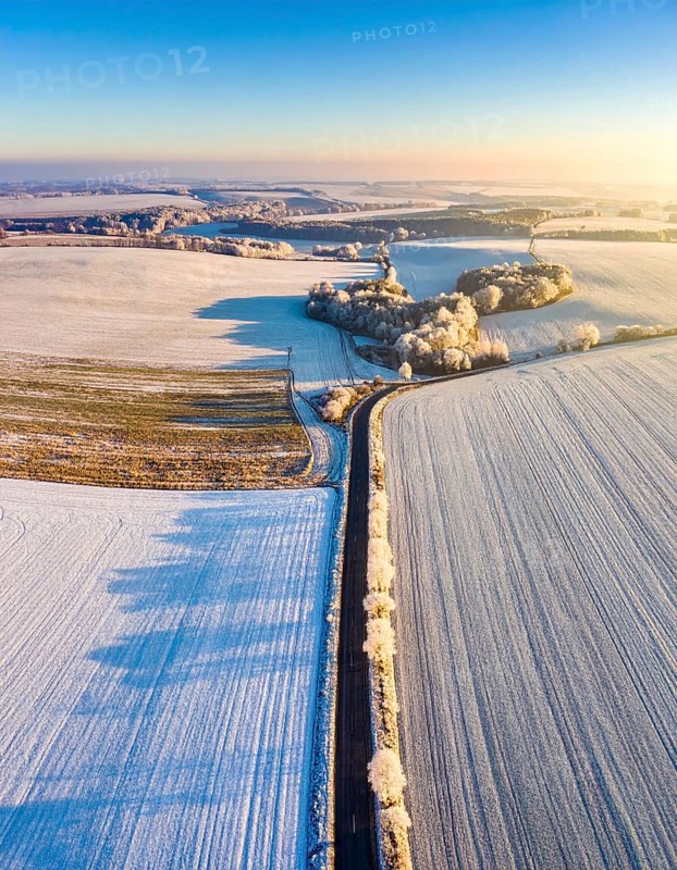 Bird Eye Perspective of Frost Covered Farmland. Seasonal Agricultural Scenery, winter and autumn scene, blue sky with golden light at sunrise, AI generated