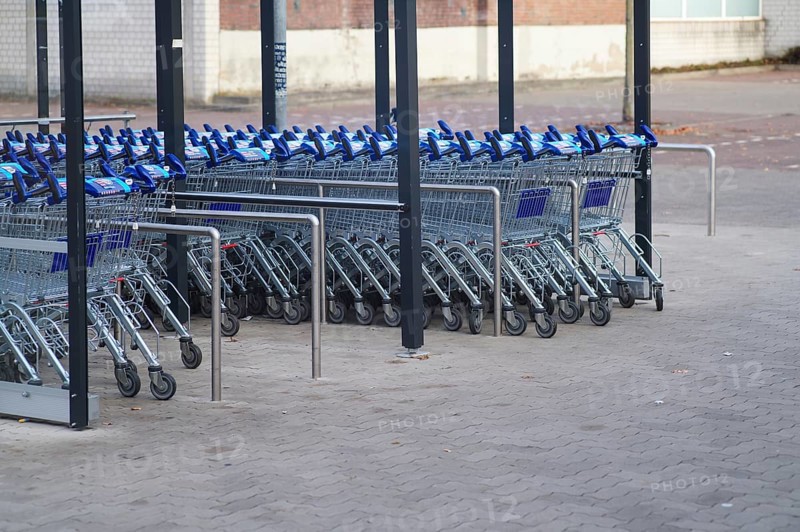 Borken, NRW, Germany, REmpty shopping carts neatly arranged in rows under a shelter in a parking lot