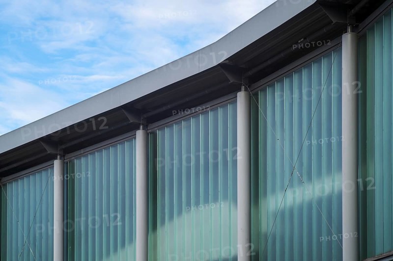 Borken, NRW, Germany, RModern building facade details showing translucent glass walls and concrete pillars under sky