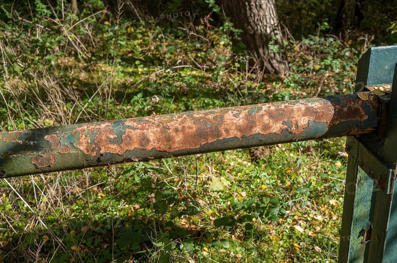 Borken, NRW, Germany, Rust and peeling paint corroding a green metal barrier in a forest setting