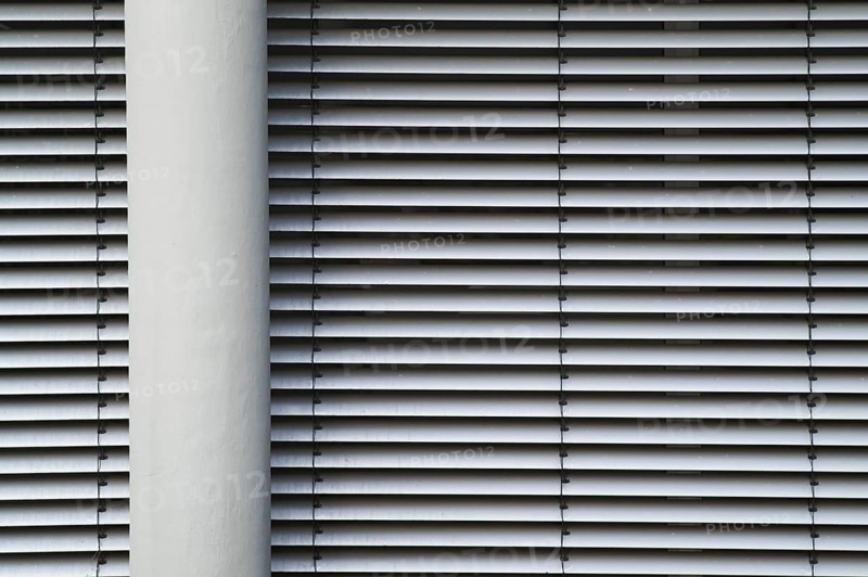 Borken, NRW, Germany, RModern building facade with horizontal lines from closed blinds and a vertical pillar