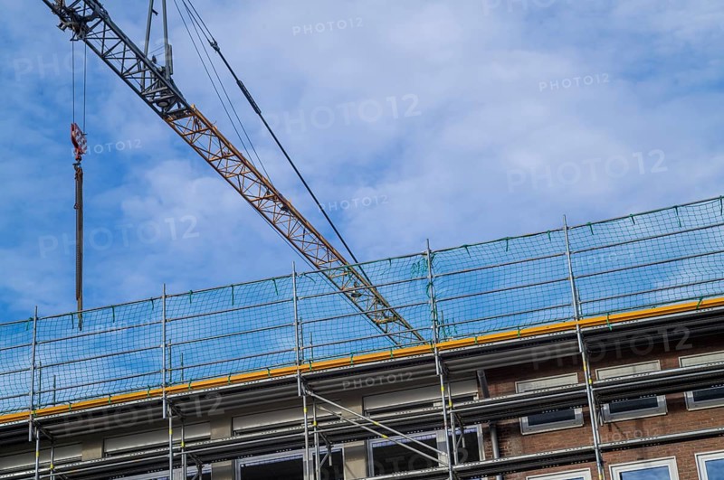 Borken, NRW, Germany, RConstruction crane and scaffolding against a blue sky, renovating a building exterior