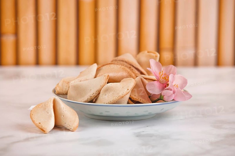 Fortune cookies in a Chinese bowl with a pink flower