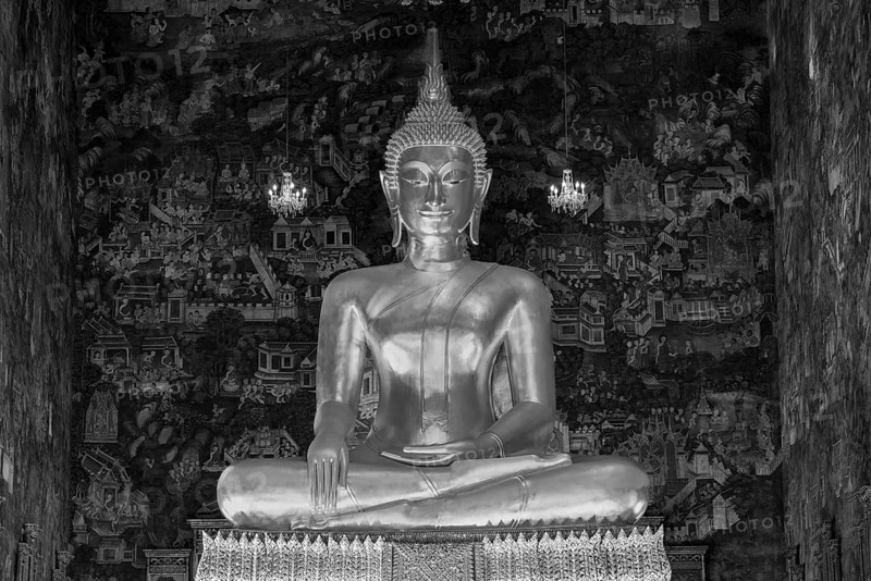 Golden Buddha statue, Phra Buddha Trilokachet surrounded by crystal chandeliers and exquisite wall paintings, interior view of Phra Ubosot or ordination hall, Wat Suthat Thepwararam, Royal Temple, Phra Nakhon, Bangkok, Thailand