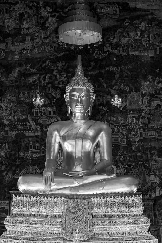 Golden Buddha statue, Phra Buddha Trilokachet surrounded by crystal chandeliers and exquisite wall paintings, interior view of Phra Ubosot or ordination hall, Wat Suthat Thepwararam, Royal Temple, Phra Nakhon, Bangkok, Thailand