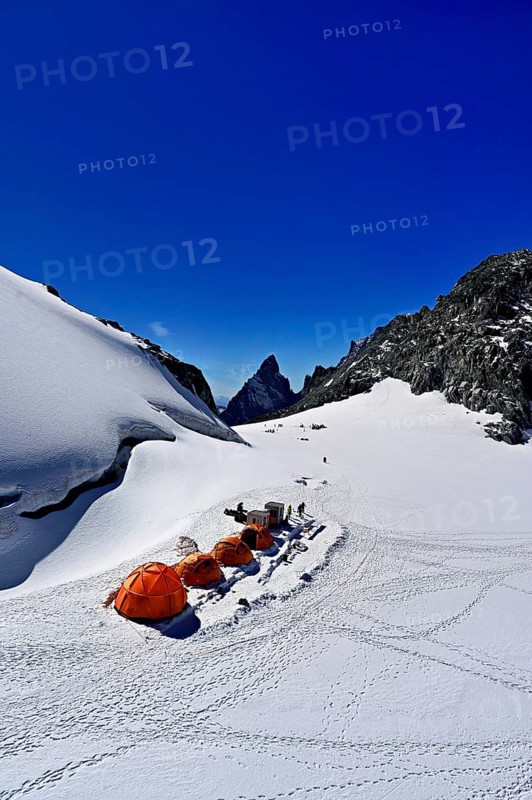 Tents on snowy areas, in the background the l'Aiguille Noire de Peuterey mountain, Pointe Helbronner viewing terrace, Chamonix-Mont-Blanc, Haute-Savoie, Italian watershed, France
