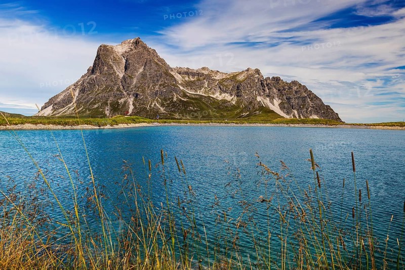 The panoramic lake on Saloberkopf with the Großer Widderstein mountain in the background and grasses in the foreground, Wart, Bregenz, Vorarlberg, Austria