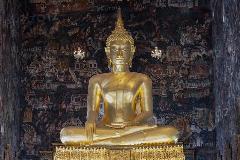 Golden Buddha statue, Phra Buddha Trilokachet surrounded by crystal chandeliers and exquisite wall paintings, interior view of Phra Ubosot or ordination hall, Wat Suthat Thepwararam, Royal Temple, Phra Nakhon, Bangkok, Thailand