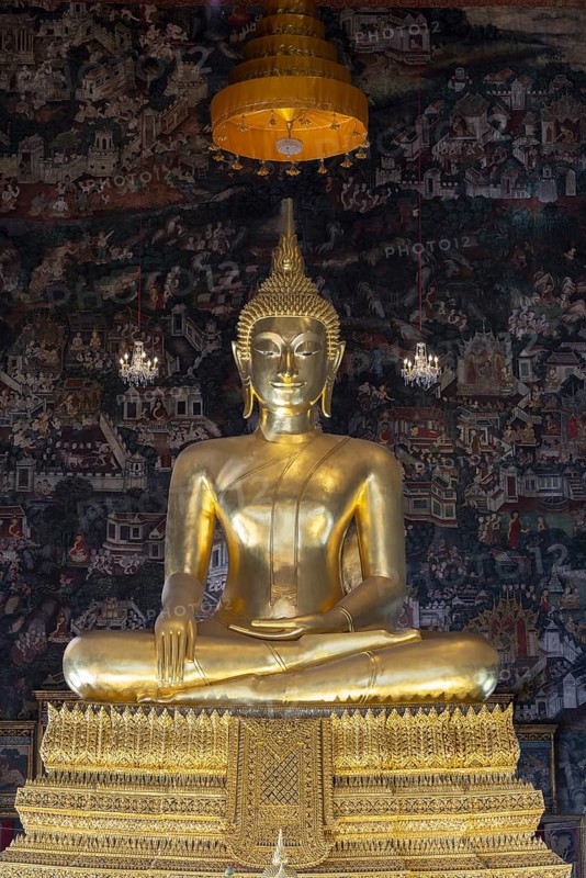 Golden Buddha statue, Phra Buddha Trilokachet surrounded by crystal chandeliers and exquisite wall paintings, interior view of Phra Ubosot or ordination hall, Wat Suthat Thepwararam, Royal Temple, Phra Nakhon, Bangkok, Thailand