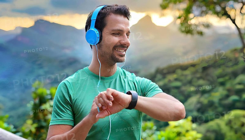 A man wearing headphones and a green shirt is smiling and looking at his watch. He is wearing a wristwatch and a watch band, AI generated