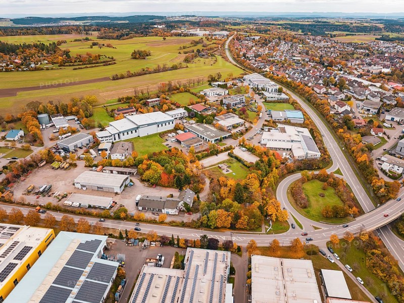 Aerial view of a city with industrial buildings, roads and autumn landscape, Dornstetten, Freudenstadt district, Germany