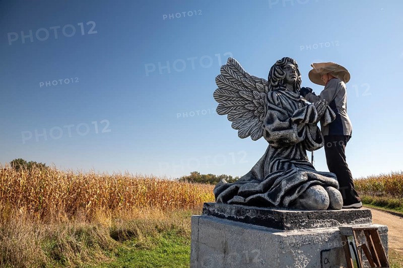 Chandler, Minnesota - Artist Primi Monteiga re-paints her concrete sculpture of an angel in the midst of Minnesota cornfields. Born in Spain, Monteiga grew up in Venezuela where she is well known for her art. She has been living in rural Minnesota since 2010