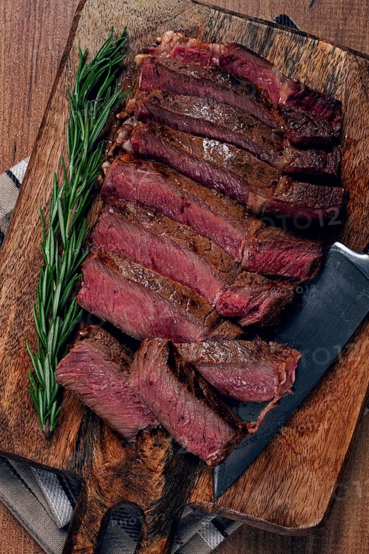 Fried steak, beef steak, rib eye steak, sliced steak, on a chopping board, top view, no people