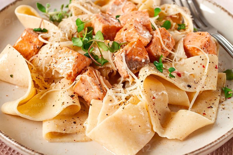 Tagliatelli pasta, with salmon slices and herbs, on a decorative plate, homemade, no people