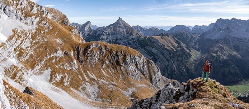 Female hiker standing on a rock and looking into the valley, hiking to Gamsjoch, down the Ahornboden valley, eastern Karwendel, Tyrol, Austria