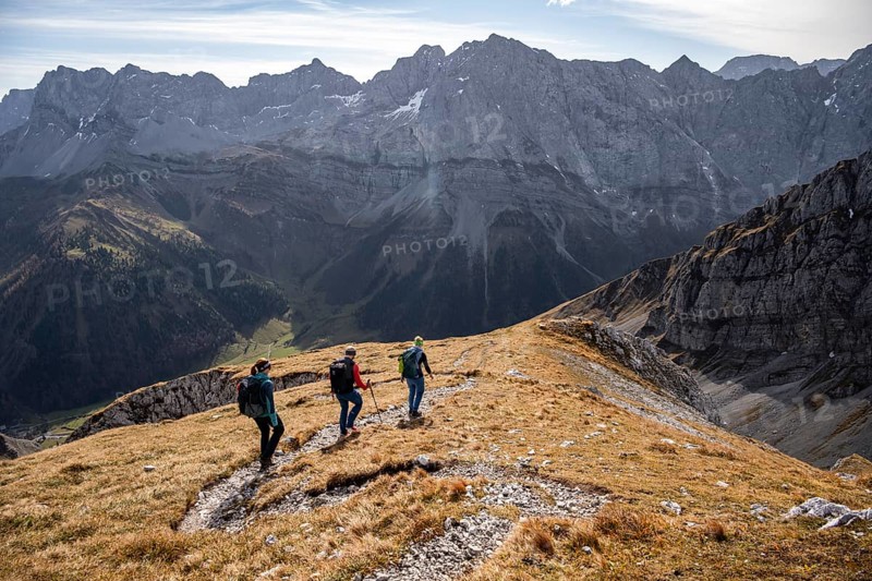 Three hikers on hiking trail, hiking to Gamsjoch, behind Dreizinkenspitze and Laliederer Wand, eastern Karwendel, Tyrol, Austria