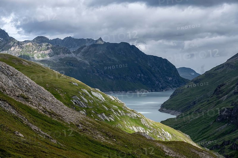 View of a lake in a valley surrounded by mountains, dramatic sky with low-hanging clouds, Lac des Dix reservoir, Valais Alps, Valais, Switzerland
