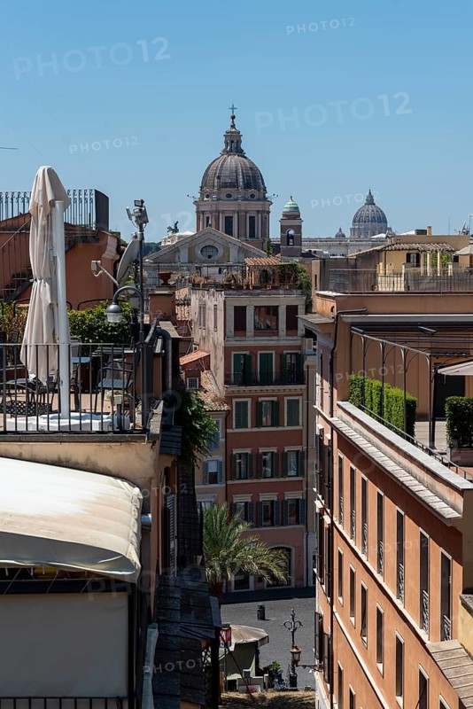 Row of houses in Rome on several church domes, including in the background the dome of St. Peter's Basilica, Rome, Italy