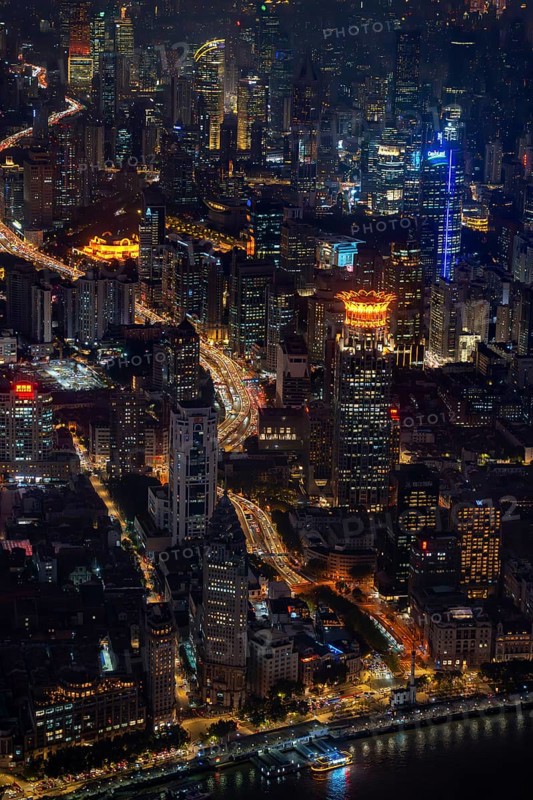 Aerial view over The Bund, Huangpu River waterfront and illuminated skyscrapers from the Shanghai Tower in Pudong at the city Shanghai at night, China