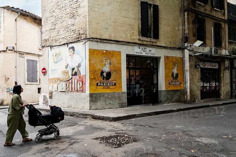 Woman with stroller, wall painting, advertisement, 1950s, corner house with old advertisement, Arles, France