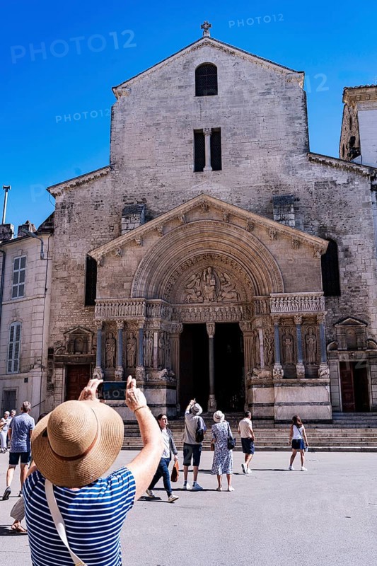 Woman with sunhat photographs St. Trophime Cathedral, Arles, France