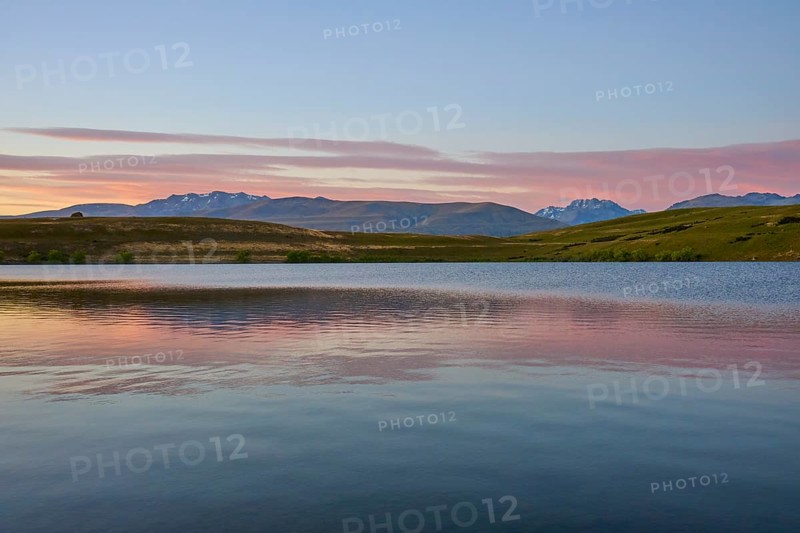 Clear lake with mountains in the background under a pink-blue morning sky, Lake McGregor, Tekapo, Canterbury, South Island, New Zealand