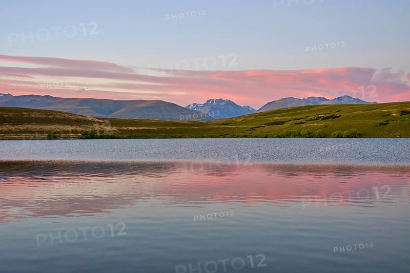 Calm lake with mountains and pink morning sky in the background, Lake McGregor, Tekapo, Canterbury, South Island, New Zealand