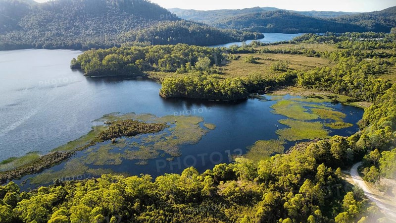 Dark lakes between the mountains of Tasmania on a sunny day, photograped with a drone