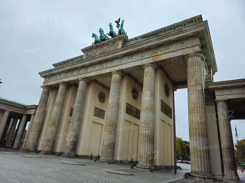 The Brandenburg Gate, monumental city gate and landmark with Doric columns and quadriga under cloudy sky, government district in 10117 Berlin, Germany