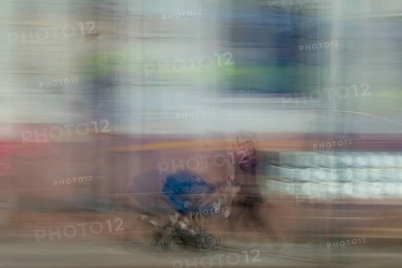 Abstract image of a woman pushing a pram in city captured using ICM intentional camera movement technique, Helsinki, Finland