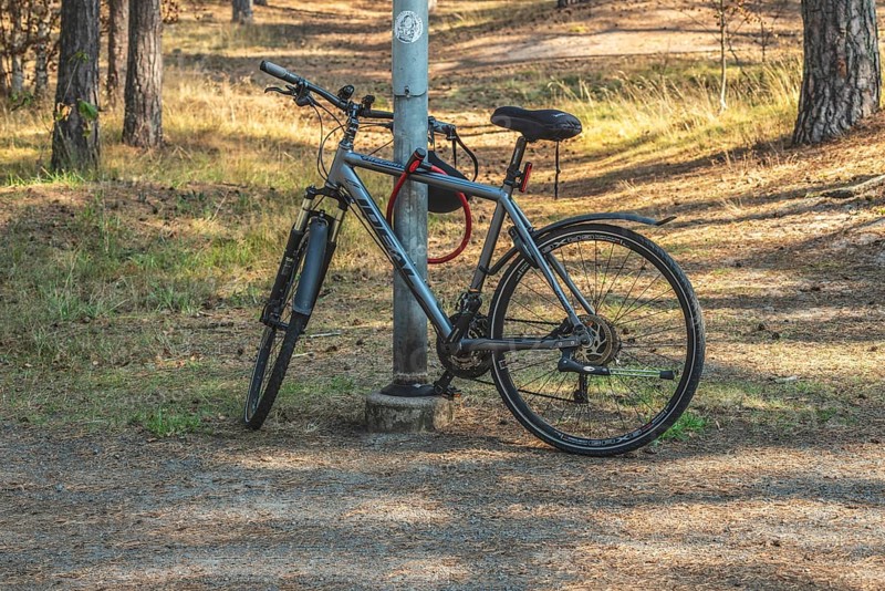 Parked modern bicycle locked to a lamppost in park in Ystad municipality, Skåne county, Sweden, Scandinavia