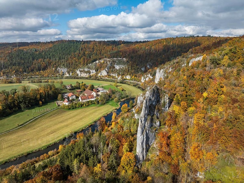 Aerial view of Käppeler Manor with St. George's Basilica near Thiergarten in the Upper Danube Valley, surrounded by autumn vegetation, on the right the raven rocks, climbing rocks, Jura limestone rocks, Sigmaringen district, Baden-Württemberg, Germany